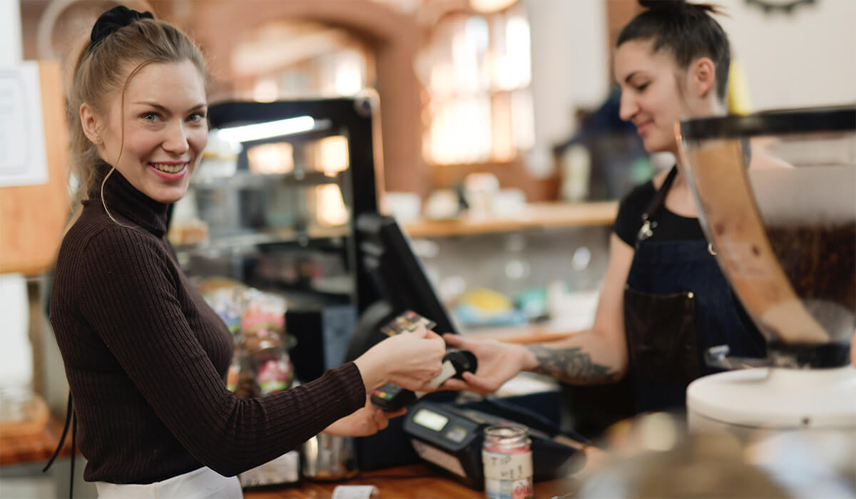 A woman in a cafe paying for coffee