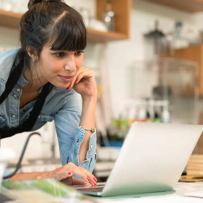 A cafe manager viewing Sales Analyst reports on a laptop