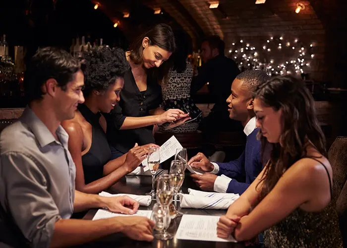 A server taking an order on a tablet in a restaurant