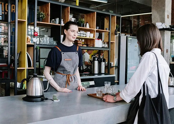 A server speaking to a customer from behind the counter