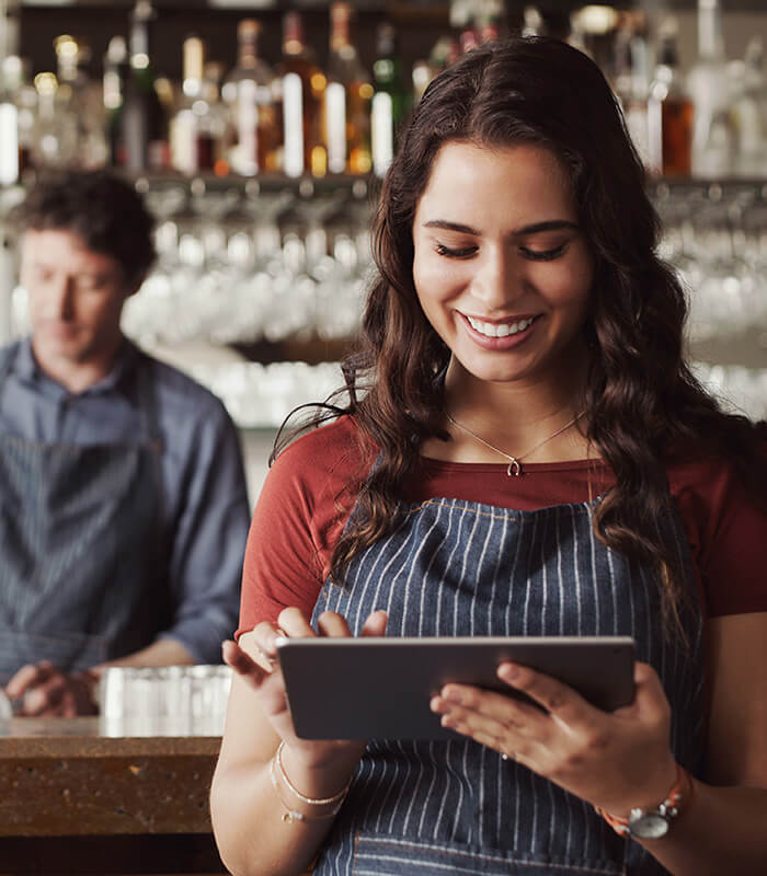 Staff using SevenRooms and PowerEPOS on a tablet in a restaurant