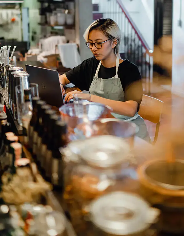 A bar operator working on a laptop