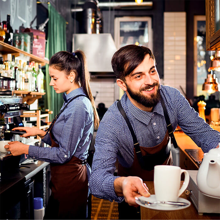 Staff working in a cafe making coffee and tea