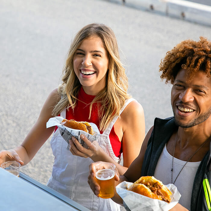 Happy customers eating a burger at a food truck