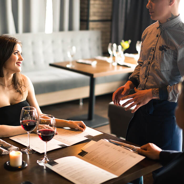 A server in a hotel explaining the menu to a customer