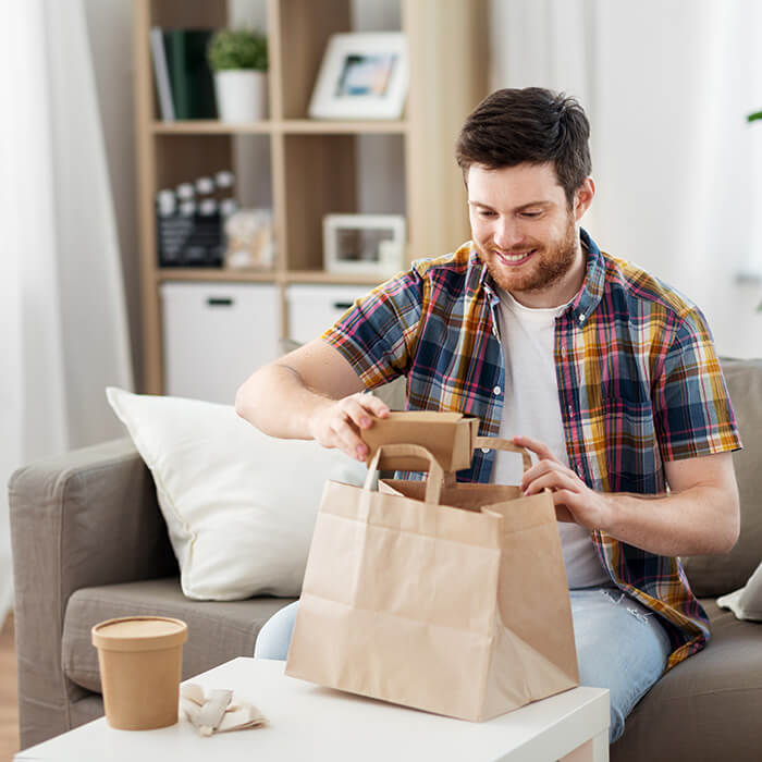 A man opening up a food delivery bag