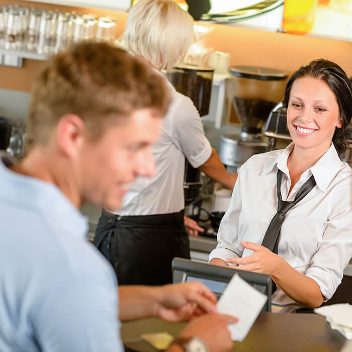 A woman serving a man at the counter in cafe