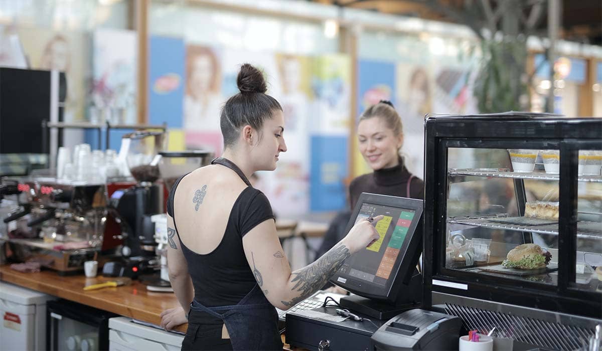 A serving person using PowerEPOS in a cafe to serve a customer.